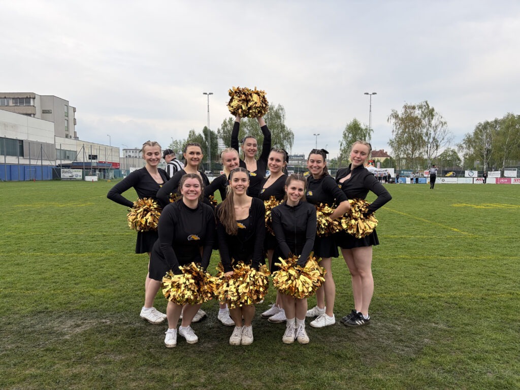 Cheerdance Team mit Gold Poms am Footballfeld